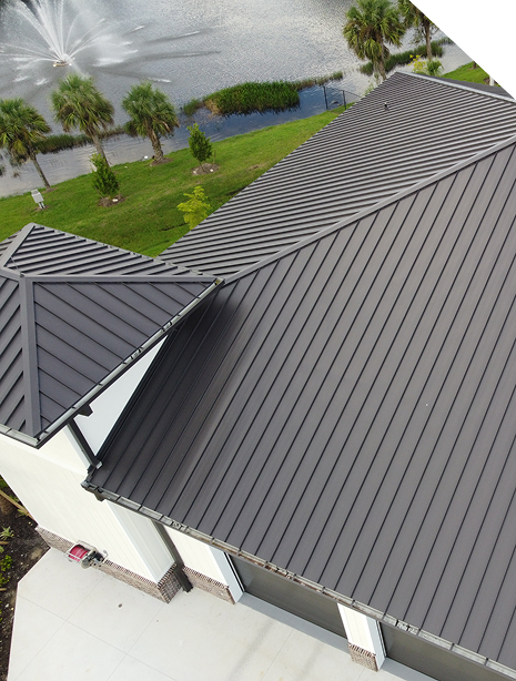 Metal roofing system with standing seam panels, designed for durability and weather resistance, overlooking a landscaped area with palm trees and a water feature, showcasing practical application for Texas climates.
