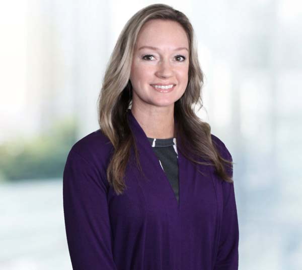 Brandi Howell, CFO of Practical Metals, smiling in professional attire against a blurred background.