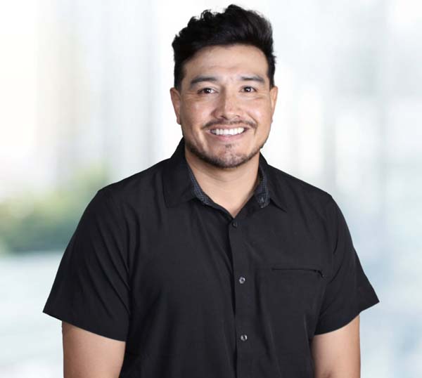 Smiling man in a black shirt representing the Practical Metals team, showcasing leadership and commitment to quality in metal construction solutions.